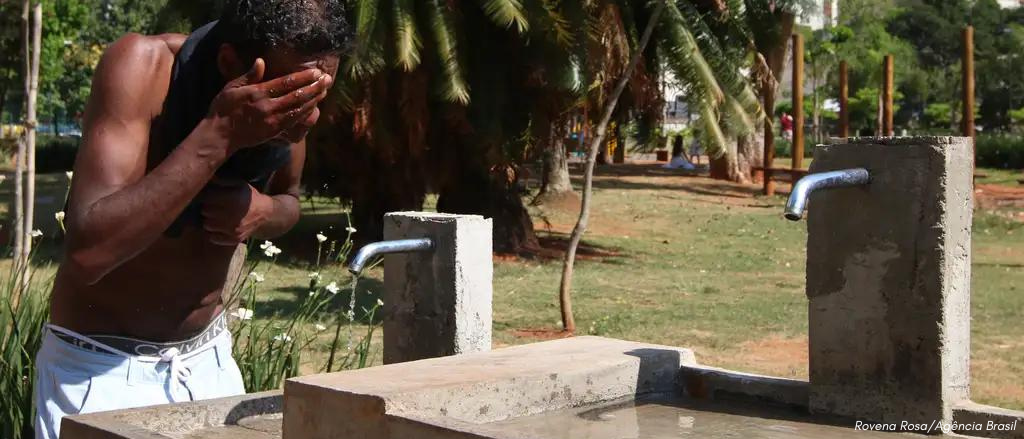 Homem se refresca durante um dia com onda de calor